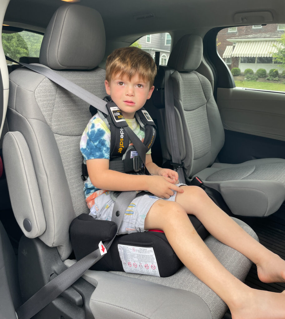 Travel Car Seat Mom - A young boy sitting in the back seat of a car.